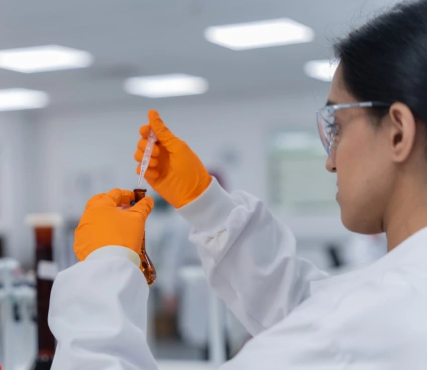 Aleema Iqbal, Broughton scientist working in laboratory whilst wearing lab safety equipment