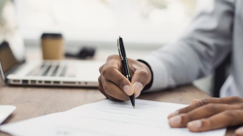 man writing at desk