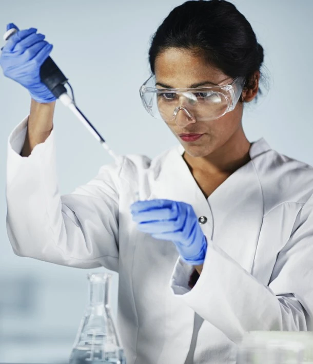 scientist in goggles and gloves working in lab