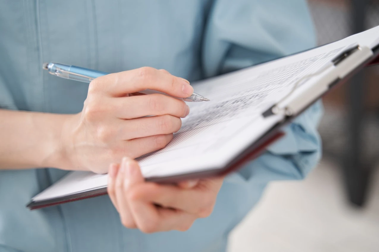 Hands holding clipboard and pen