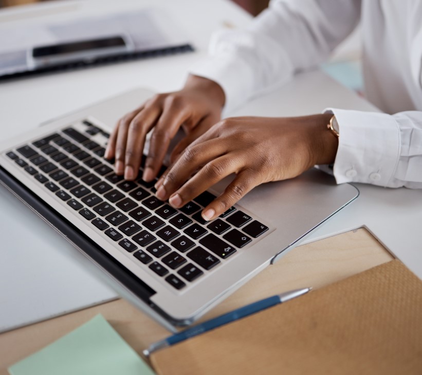 professional typing at a laptop