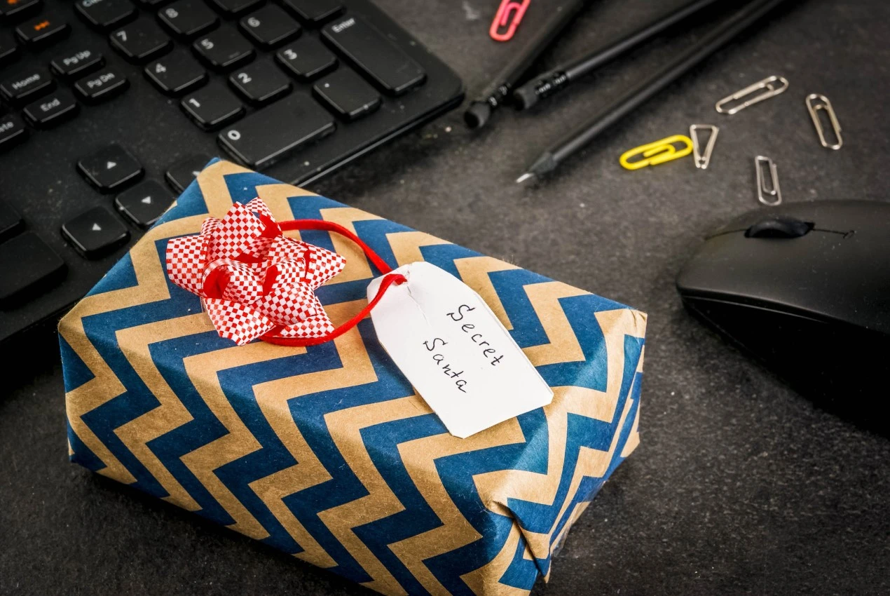 Secret Santa gift on desk with keyboard, mouse, pens and paperclips